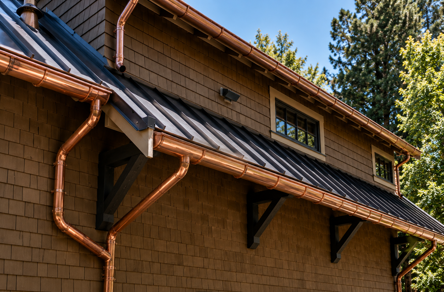 Copper half-round gutters and round downspouts on a cedar shake home