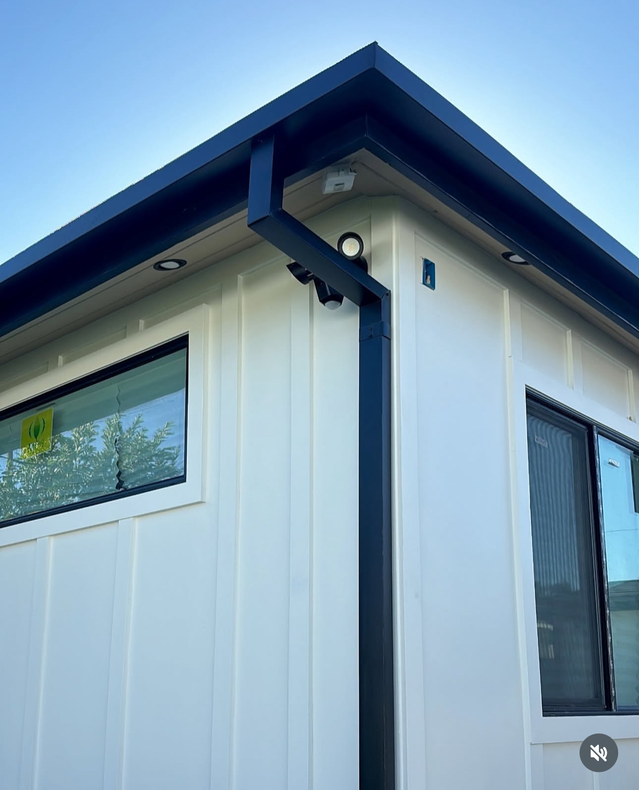 Dark gutter and downspout on a white home